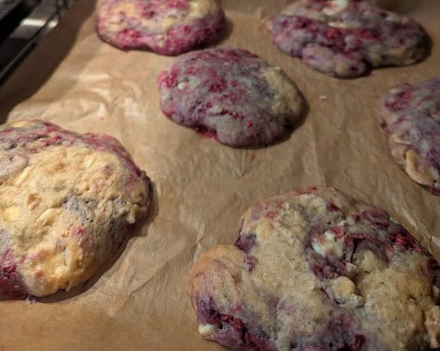 top-down photograph of raspberry and white chocolate cookies in a baking tray